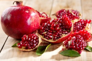 pomegranate with leafs on wooden table