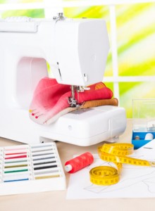 Sewing machine with colorful fabrics, threads and other sewing accesories.