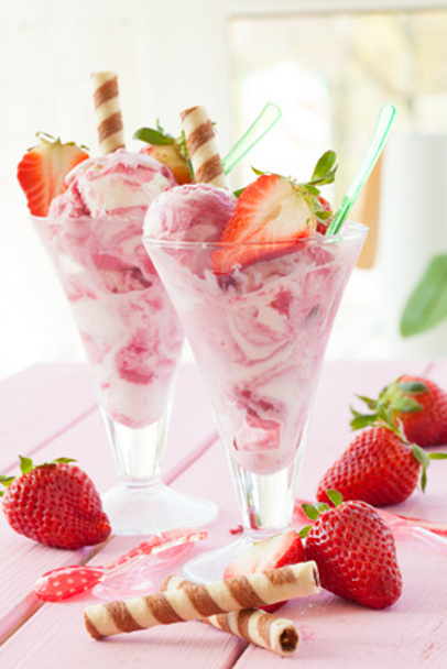 Milcheis mit frischen Erdbeeren auf rosa rustikalem Hintergrund